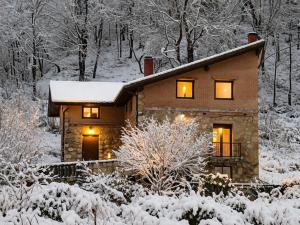 a house in the snow with lights on at RINCON DE MUTILOA Balcón del Aitzgorri HabTuristica in Mutiloa