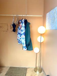 a closet with a rack with a bag and two lights at Rom i privat loftsleilighet med utsikt in Bergen