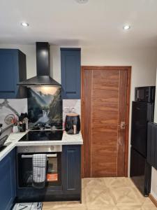 a kitchen with blue cabinets and a stove top oven at Nivahana in Edinburgh +8 photos