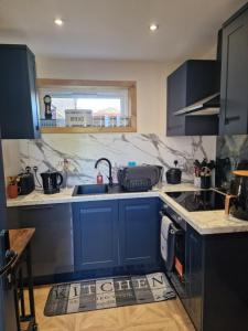 a kitchen with blue cabinets and a sink at Nivahana in Edinburgh
