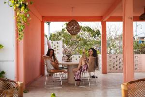 two women sitting at a table on a porch at Casa de Rosa in Puerto Escondido