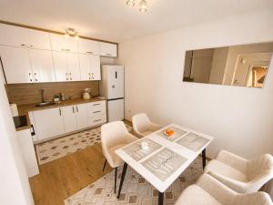 a small kitchen with a white table and chairs at Sara Luxe Family in Konjic