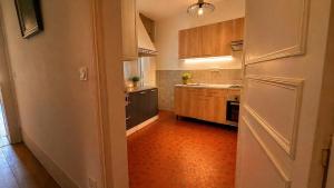 a kitchen with wooden cabinets and an orange floor at Les jardins d'Elise in Lure +8 photos