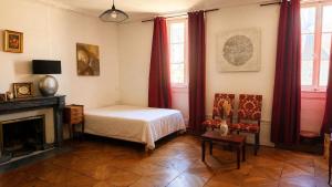 a bedroom with a bed and a fireplace at Les jardins d'Elise in Lure