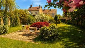 a garden with chairs and a table and a house at Les jardins d'Elise in Lure