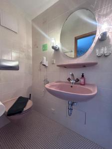 a bathroom with a sink and a mirror and a toilet at Gästehaus Gute Quelle in Cochem