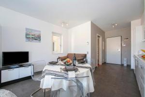 a living room with a table and a television at Via al Chioso in Lugano