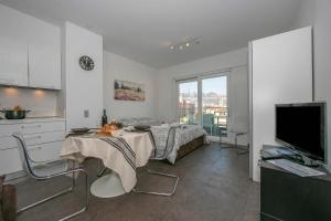 a kitchen and a living room with a table and a television at Via al Chioso in Lugano