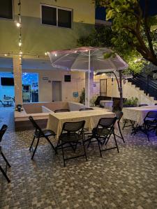 a table and chairs with an umbrella in a building at Casa Faustos in Mérida