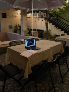 a laptop computer sitting on a table with a book at Casa Faustos in Mérida