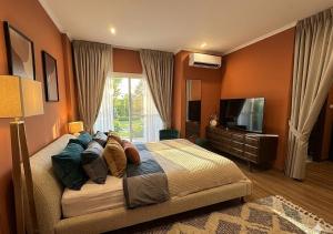 a bedroom with a large bed and a television at SvoyLuX Primo 3BR Gated House Near Pier and Muay Thai Street in Phuket