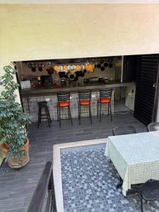 a patio with a bar with chairs and a table at Casa Faustos in Mérida