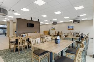 a dining room with tables and chairs and a tv at Best Western Plus Neepawa Hotel in Neepawa
