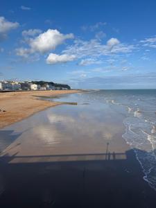 a beach with a shadow of a person on the water at Central location location in Hollington