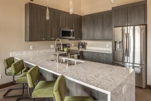 a kitchen with a granite counter top and a refrigerator at Alpenglow Condo 26A in Big Sky