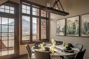 a dining room with a table and chairs and windows at Alpenglow Condo 26A in Big Sky