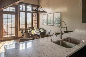 a kitchen with a sink and a table with chairs at Alpenglow Condo 26A in Big Sky +29 photos