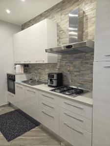 a kitchen with white cabinets and a stove top oven at Living Monza Arengario in Monza