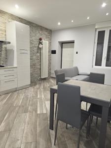 a dining room with a table and chairs and a kitchen at Living Monza Arengario in Monza +3 photos