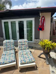 two chairs sitting on a patio in front of a house at Los Machos surf shack in Ceiba