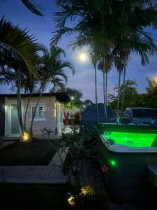 a house with a green lit up truck in a yard at Los Machos surf shack in Ceiba