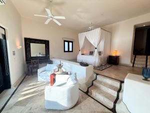 a living room with a bed and a ceiling fan at Tentaciones Boutique Hotel - Ocean View & Private Pools - Adults Only in Zihuatanejo