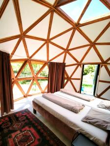 two beds in a large room with large windows at Retreat House Herneacova in Herneacova