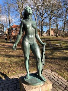 a statue of a woman standing in a park at Lille Skovgaarden ved parken med gratis parkering in Randers