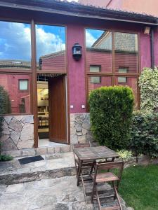 a house with a table and a bench in front of it at Las Ventanas del Cielo, Ávila in Ávila