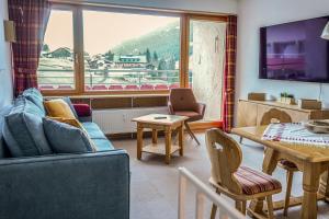 a living room with a couch and a table at Appartement Swing in Mittelberg