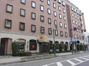 un edificio alto en una calle de la ciudad con luz de la calle en Hotel New Station, en Matsumoto