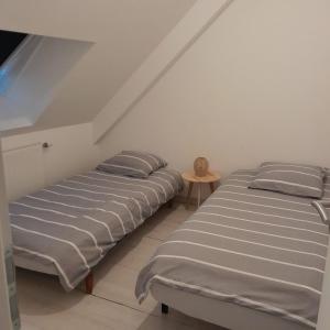 two beds sitting next to each other in a room at Maison 3 chambres et jardin in Le Mans
