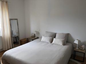 a bedroom with a large white bed with two pillows at Maison 3 chambres et jardin in Le Mans