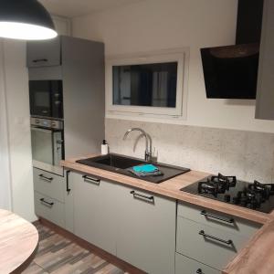 a kitchen with a sink and a stove at Maison 3 chambres et jardin in Le Mans