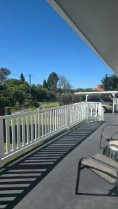 a white fence and benches on a walkway at Spacious & Sun-Filled Highlands Retreat in Moss Vale