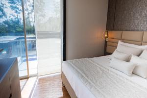 a bedroom with a bed and a large window at Libertg Hotels Medellin in Copacabana