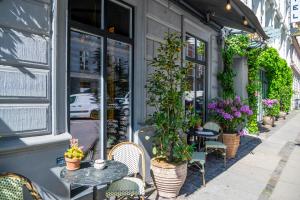 a cafe with tables and chairs and potted plants at Axel Guldsmeden in Copenhagen
