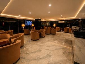 a lobby with chairs and a television in a building at سرايا الغربية للشقق المخدومة - saraya algharbiyya Establishment in Jeddah