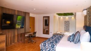 a bedroom with a bed and a desk and a television at Libertg Hotels Medellin in Copacabana