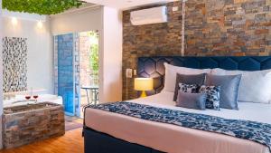 a bedroom with a large bed and a brick wall at Libertg Hotels Medellin in Copacabana