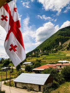 a flag flying in front of a small village at Ninama in Mestia +98 photos