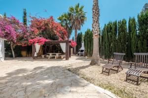 a park with benches and a tree with pink flowers at Villa Alba in Santa Eularia des Riu