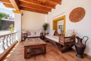 a porch with wooden furniture and a table at Villa Alba in Santa Eularia des Riu