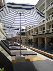 uma piscina com um guarda-sol no meio de um edifício em Phangan Pearl Villa em Haad Rin
