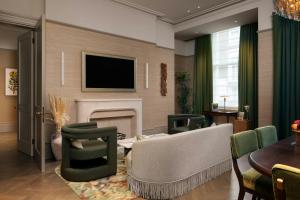a living room with a fireplace and a tv at Montcalm Mayfair, Autograph Collection in London