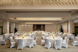 a banquet hall with white tables and white chairs at Montcalm Mayfair, Autograph Collection in London +75 photos