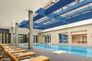 a swimming pool with lounge chairs and a blue ceiling at Le Méridien Changzhou in Changzhou