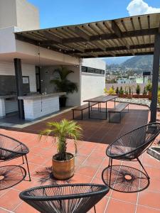 a patio with tables and chairs on a roof at Mumbai SkyLine Luxury Suite in Quito