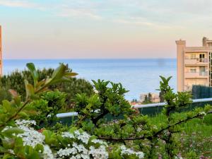 a view of the ocean from a garden with flowers at Cocoon Studio Ciel de Fabron in Nice