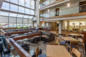 a restaurant with tables and chairs and windows at Drury Inn & Suites St. Louis Airport in Edmundson